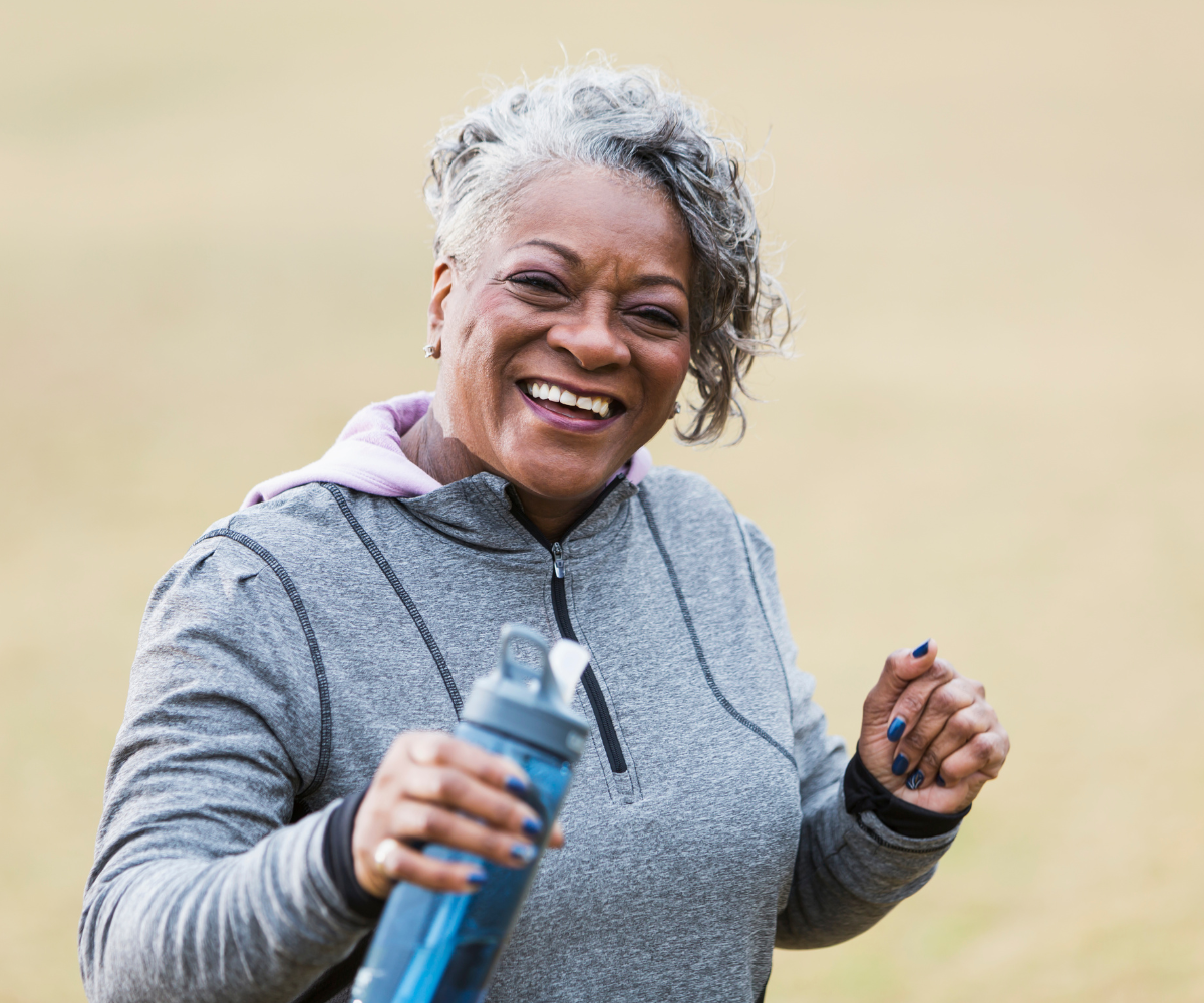 A woman smiling holding a water bottle