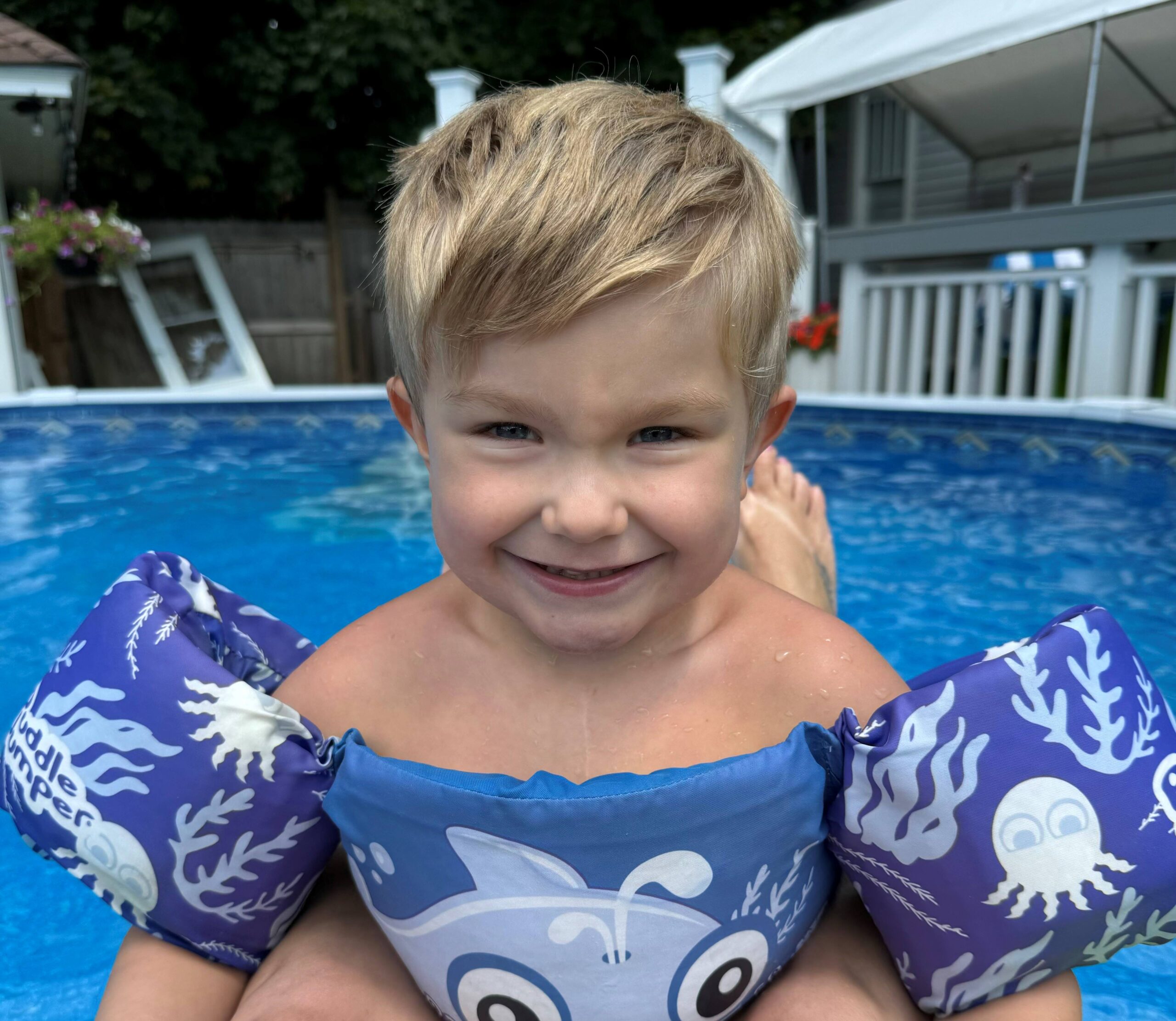 Finn Taylor smiling by a pool