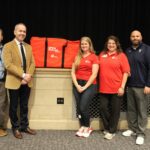 Individuals pose for photo with donated CPR kit.