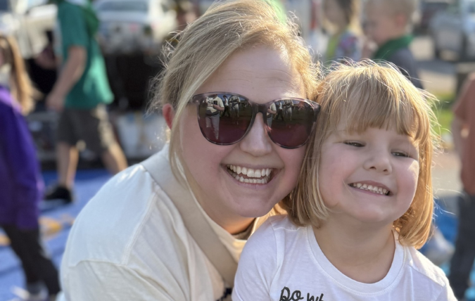 A mom and daughter smiling