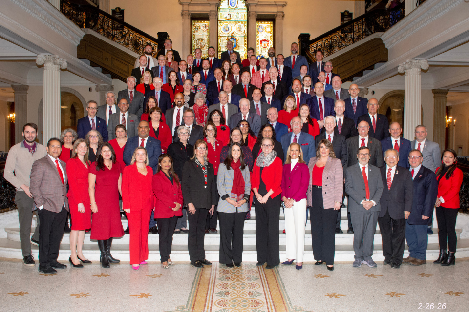 Massachusetts lawmakers gather on the Grand Staircase at the State House in Boston