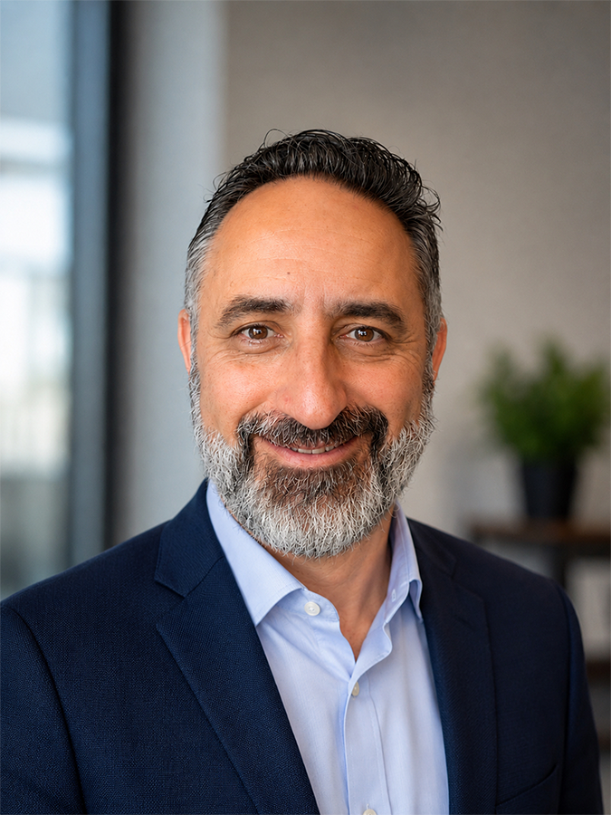smiling man with beard and wearing a button down shirt and jacket