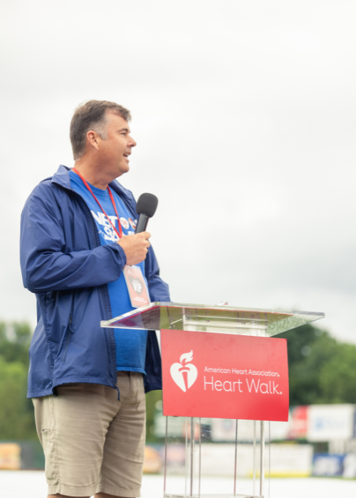 man standing at podium with microphone.