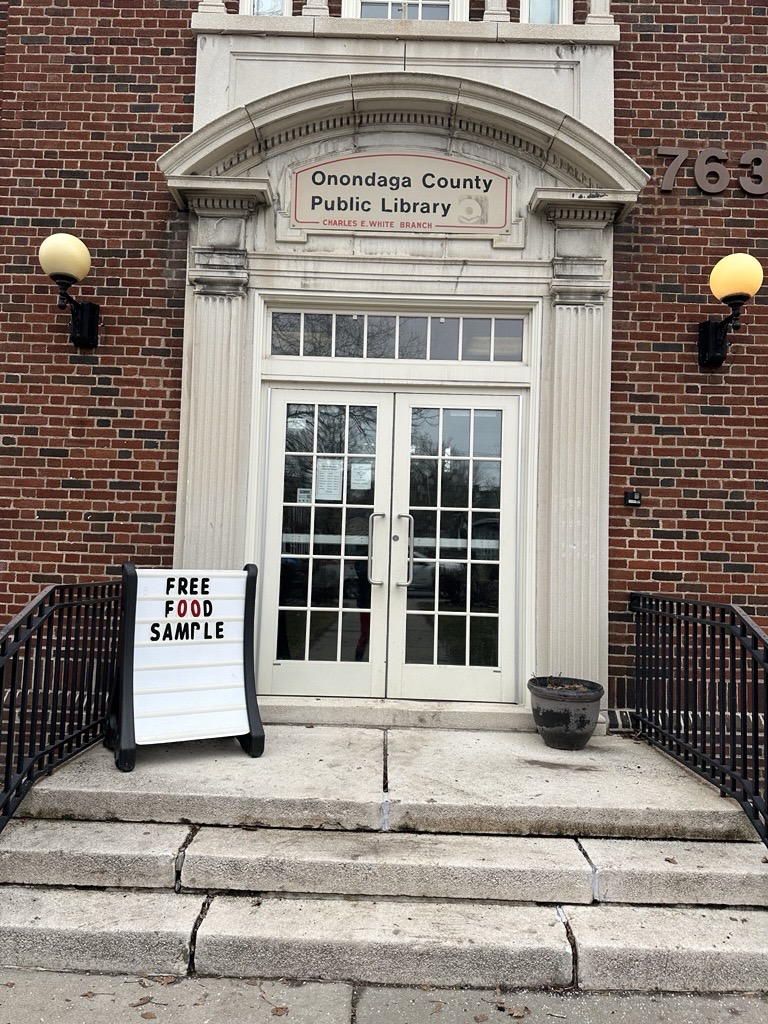 Exterior of a building with a sign that says "free food sample"